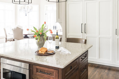 Kitchen - mid-sized transitional l-shaped dark wood floor and brown floor kitchen idea in Charlotte with an undermount sink, beaded inset cabinets, white cabinets, quartz countertops, porcelain backsplash, stainless steel appliances and an island