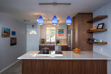 Mid-sized transitional u-shaped porcelain tile eat-in kitchen photo in Hawaii with a single-bowl sink, flat-panel cabinets, dark wood cabinets, quartz countertops, beige backsplash, glass tile backsplash, stainless steel appliances and a peninsula