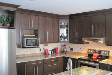 Example of a minimalist l-shaped eat-in kitchen design in Ottawa with dark wood cabinets, granite countertops, beige backsplash, ceramic backsplash, stainless steel appliances, an island and flat-panel cabinets