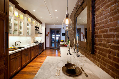 Mid-sized farmhouse galley medium tone wood floor and brown floor eat-in kitchen photo in New York with an undermount sink, shaker cabinets, medium tone wood cabinets, marble countertops, gray backsplash, marble backsplash, paneled appliances and a peninsula
