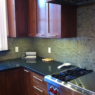 Example of a large trendy u-shaped light wood floor eat-in kitchen design in Philadelphia with shaker cabinets, medium tone wood cabinets, granite countertops, green backsplash, an island, an undermount sink and stainless steel appliances