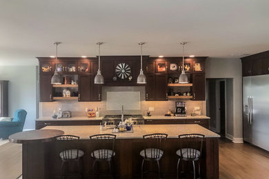 Example of a large transitional brown floor eat-in kitchen design in Philadelphia with dark wood cabinets, quartzite countertops, stainless steel appliances, an island and beige countertops