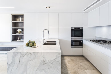 Inspiration for a small contemporary u-shaped kitchen/diner in Sydney with a built-in sink, flat-panel cabinets, white cabinets, marble worktops, grey splashback, mosaic tiled splashback, stainless steel appliances, limestone flooring and an island.