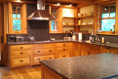 Mid-sized arts and crafts u-shaped light wood floor and brown floor eat-in kitchen photo in Boston with shaker cabinets, medium tone wood cabinets, granite countertops, a double-bowl sink, gray backsplash, stone slab backsplash, stainless steel appliances and an island