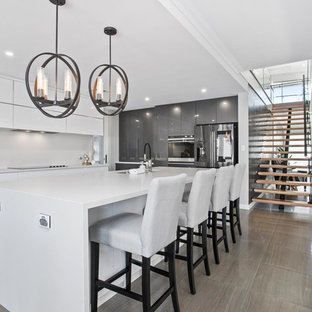 Photo of a mid-sized contemporary galley kitchen in Perth with an undermount sink, flat-panel cabinets, white splashback, stainless steel appliances, grey floor and multiple islands.