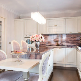 Cette image montre une cuisine traditionnelle en L de taille moyenne avec des portes de placard blanches, un plan de travail en granite, un électroménager blanc, un sol en bois foncé, un îlot central, un sol marron et un plan de travail violet.