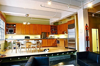 Example of an eclectic l-shaped cork floor eat-in kitchen design in New Orleans with raised-panel cabinets, medium tone wood cabinets, concrete countertops, stainless steel appliances and no island