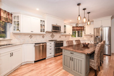 Example of a large trendy l-shaped medium tone wood floor and brown floor eat-in kitchen design in New York with a drop-in sink, shaker cabinets, white cabinets, laminate countertops, beige backsplash, stone tile backsplash, stainless steel appliances, an island and beige countertops