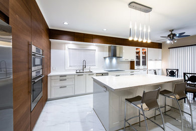 Eat-in kitchen - mid-sized contemporary l-shaped white floor eat-in kitchen idea in Toronto with shaker cabinets, white cabinets, white backsplash, stainless steel appliances, an island and white countertops