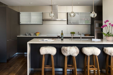 Inspiration för moderna l-kök, med en undermonterad diskho, släta luckor, grå skåp, stänkskydd med metallisk yta, mörkt trägolv, en halv köksö och brunt golv