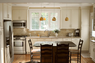 Inspiration för ett mellanstort vintage kök, med en undermonterad diskho, luckor med upphöjd panel, beige skåp, granitbänkskiva, brunt stänkskydd, stänkskydd i stenkakel, rostfria vitvaror, mellanmörkt trägolv, en köksö och brunt golv