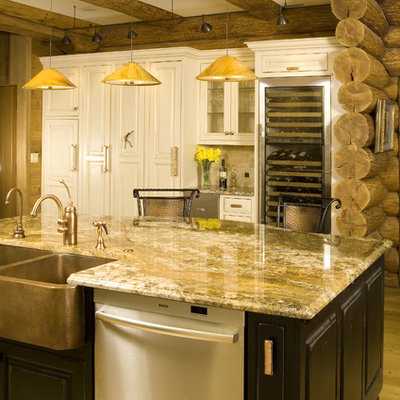 Example of a mid-sized mountain style l-shaped light wood floor open concept kitchen design in Seattle with a farmhouse sink, raised-panel cabinets, white cabinets, stainless steel appliances, granite countertops, beige backsplash and an island