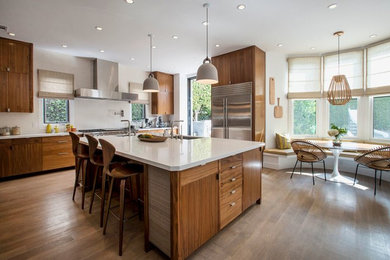 Moderne Wohnküche mit Unterbauwaschbecken, flächenbündigen Schrankfronten, hellbraunen Holzschränken, Küchengeräten aus Edelstahl, braunem Holzboden und Kücheninsel in Los Angeles
