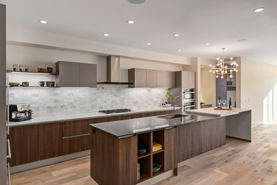Inspiration for a large contemporary l-shaped ceramic tile eat-in kitchen remodel in Calgary with a double-bowl sink, flat-panel cabinets, medium tone wood cabinets, quartz countertops, white backsplash, cement tile backsplash, stainless steel appliances and an island