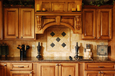 Example of a mid-sized classic l-shaped dark wood floor and brown floor eat-in kitchen design in New York with a double-bowl sink, raised-panel cabinets, dark wood cabinets, granite countertops, beige backsplash, ceramic backsplash, black appliances and an island