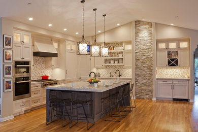 Open concept kitchen - large transitional l-shaped medium tone wood floor open concept kitchen idea in Orange County with an undermount sink, recessed-panel cabinets, white cabinets, quartzite countertops, multicolored backsplash, stone tile backsplash, paneled appliances and an island
