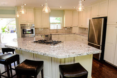 Foto på ett mellanstort lantligt kök, med en dubbel diskho, luckor med profilerade fronter, vita skåp, marmorbänkskiva, flerfärgad stänkskydd, rostfria vitvaror, mörkt trägolv och en köksö