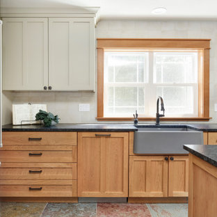 Design ideas for a mid-sized country u-shaped separate kitchen in Portland with a farmhouse sink, shaker cabinets, medium wood cabinets, granite benchtops, white splashback, ceramic splashback, stainless steel appliances, slate floors, with island, multi-coloured floor and black benchtop.