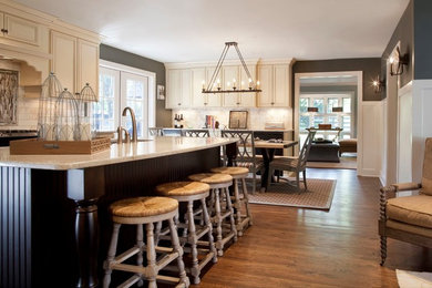 Exempel på ett stort klassiskt l-kök, med luckor med infälld panel, vita skåp, granitbänkskiva, vitt stänkskydd, stänkskydd i keramik, mellanmörkt trägolv och en köksö