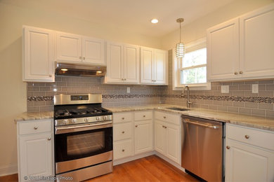 Example of a mid-sized transitional u-shaped medium tone wood floor kitchen design in Providence with an undermount sink, raised-panel cabinets, white cabinets, granite countertops, gray backsplash, subway tile backsplash, stainless steel appliances and no island