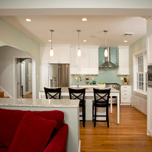 Mid-sized transitional open concept kitchen ideas - Example of a mid-sized transitional single-wall medium tone wood floor open concept kitchen design in DC Metro with an undermount sink, shaker cabinets, white cabinets, quartz countertops, blue backsplash, stainless steel appliances, an island and glass tile backsplash