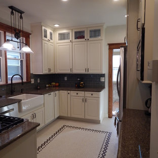 Mid-sized arts and crafts u-shaped eat-in kitchen in Denver with a farmhouse sink, raised-panel cabinets, white cabinets, quartz benchtops, green splashback, glass tile splashback, stainless steel appliances, ceramic floors and no island.