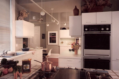 フィラデルフィアにあるモダンスタイルのおしゃれなキッチン (ダブルシンク、フラットパネル扉のキャビネット、黄色いキャビネット、タイルカウンター、マルチカラーのキッチンパネル、セラミックタイルのキッチンパネル、シルバーの調理設備) の写真