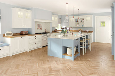 Large traditional l-shaped kitchen/diner in Oxfordshire with shaker cabinets, blue cabinets and an island.