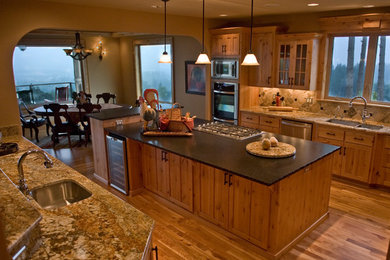 Eat-in kitchen - mid-sized traditional u-shaped marble floor eat-in kitchen idea in Portland with a double-bowl sink, raised-panel cabinets, medium tone wood cabinets, marble countertops, beige backsplash, ceramic backsplash, stainless steel appliances and an island