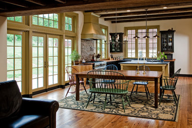 Large cottage l-shaped eat-in kitchen photo in Philadelphia with glass-front cabinets, black cabinets and an island