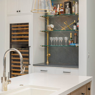 Coastal open concept kitchen pictures - Example of a beach style u-shaped light wood floor open concept kitchen design in Seattle with a single-bowl sink, recessed-panel cabinets, light wood cabinets, quartzite countertops, black backsplash, porcelain backsplash, two islands and black countertops
