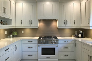 Example of a mid-sized transitional u-shaped ceramic tile and beige floor eat-in kitchen design in Vancouver with an undermount sink, shaker cabinets, white cabinets, quartz countertops, beige backsplash, ceramic backsplash, paneled appliances and an island