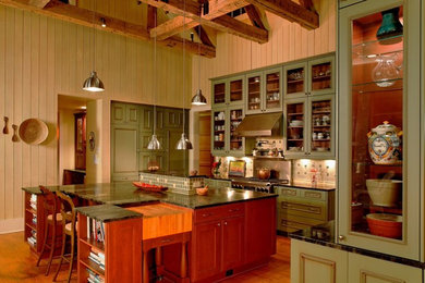 Example of a large eclectic l-shaped medium tone wood floor open concept kitchen design in Charleston with glass-front cabinets, green cabinets, beige backsplash, stainless steel appliances and an island