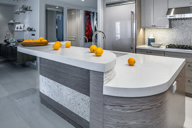 This is an example of a medium sized modern l-shaped open plan kitchen in Phoenix with a submerged sink, flat-panel cabinets, beige cabinets, engineered stone countertops, multi-coloured splashback, mosaic tiled splashback, integrated appliances, porcelain flooring, an island, white floors and white worktops.