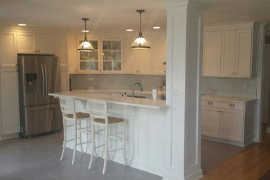Transitional l-shaped open concept kitchen photo in Indianapolis with an undermount sink, recessed-panel cabinets, white cabinets, marble countertops, white backsplash, stainless steel appliances and an island