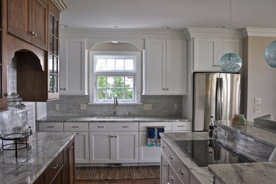 Huge beach style dark wood floor and beige floor eat-in kitchen photo in Providence with a single-bowl sink, recessed-panel cabinets, white cabinets, quartzite countertops, blue backsplash, glass tile backsplash, stainless steel appliances and an island