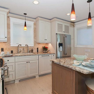 Design ideas for a small beach style l-shaped open plan kitchen in Seattle with an undermount sink, louvered cabinets, white cabinets, granite benchtops, beige splashback, stone tile splashback, stainless steel appliances, porcelain floors and with island.