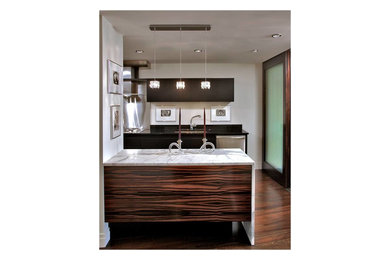 Diseño de cocina lineal moderna grande abierta con una isla, puertas de armario de madera en tonos medios, encimera de mármol, electrodomésticos de acero inoxidable y suelo de madera en tonos medios
