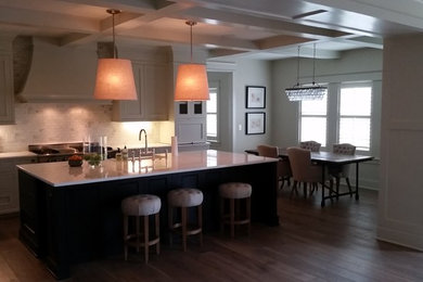 Example of a mid-sized transitional l-shaped dark wood floor and brown floor eat-in kitchen design in Grand Rapids with shaker cabinets, white cabinets, marble countertops, an island, a farmhouse sink, white backsplash, mosaic tile backsplash and stainless steel appliances