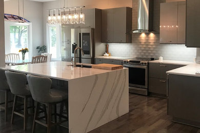 Example of a transitional u-shaped brown floor kitchen design in Raleigh with an integrated sink, flat-panel cabinets, gray cabinets, marble countertops and white countertops