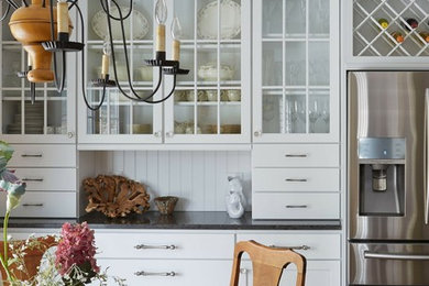 Inspiration for a mid-sized timeless u-shaped eat-in kitchen remodel in Milwaukee with a farmhouse sink, recessed-panel cabinets, white cabinets, quartz countertops, white backsplash, stainless steel appliances and subway tile backsplash