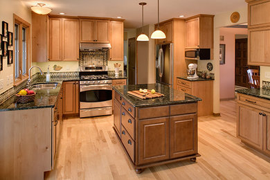 Inspiration for a mid-sized timeless l-shaped light wood floor eat-in kitchen remodel in Milwaukee with a double-bowl sink, shaker cabinets, medium tone wood cabinets, onyx countertops, multicolored backsplash, stainless steel appliances and an island