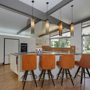 Inspiration for a modern u-shaped kitchen in Los Angeles with flat-panel cabinets, white cabinets, orange splashback and panelled appliances.
