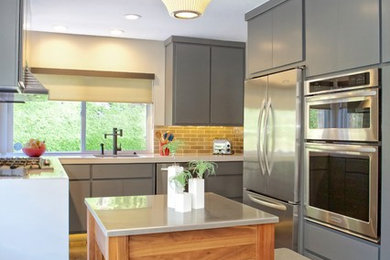 Example of a mid-sized minimalist laminate floor enclosed kitchen design in San Diego with an undermount sink, flat-panel cabinets, gray cabinets, quartz countertops, gray backsplash, ceramic backsplash and stainless steel appliances