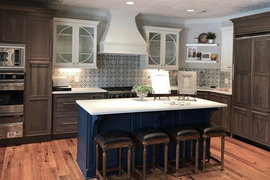 Large country l-shaped medium tone wood floor and brown floor eat-in kitchen photo in Raleigh with an undermount sink, shaker cabinets, quartz countertops, cement tile backsplash, stainless steel appliances and an island