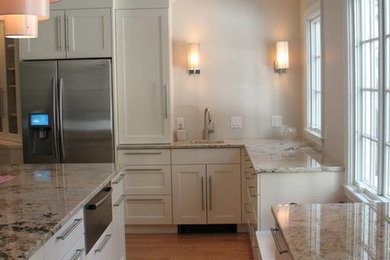 Example of a large classic galley medium tone wood floor open concept kitchen design in Boston with white cabinets, stainless steel appliances and an island