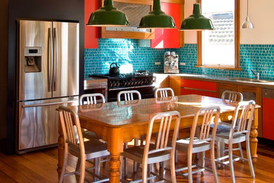 オークランドにあるエクレクティックスタイルのおしゃれなキッチン (フラットパネル扉のキャビネット、赤いキャビネット、モザイクタイルのキッチンパネル、シルバーの調理設備) の写真