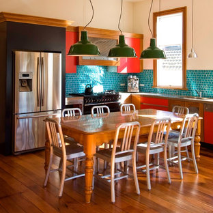 Foto di una cucina eclettica con ante lisce, ante rosse, paraspruzzi con piastrelle a mosaico e elettrodomestici in acciaio inossidabile