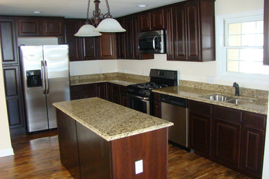 Eat-in kitchen - mid-sized l-shaped vinyl floor eat-in kitchen idea in Chicago with a double-bowl sink, raised-panel cabinets, dark wood cabinets, granite countertops, stainless steel appliances and an island