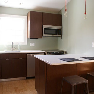 Inspiration for a small modern l-shaped eat-in kitchen in New York with an integrated sink, flat-panel cabinets, dark wood cabinets, quartz benchtops, stainless steel appliances, bamboo floors and a peninsula.